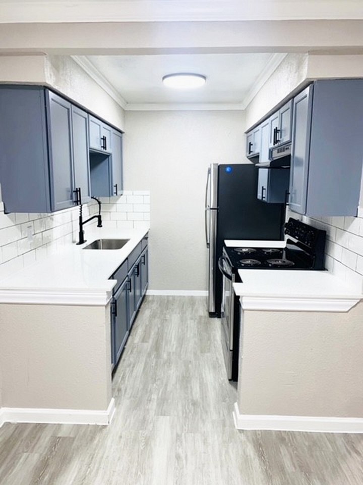 Premium kitchen with gray cabinets, white countertops, subway tile and black hardware
