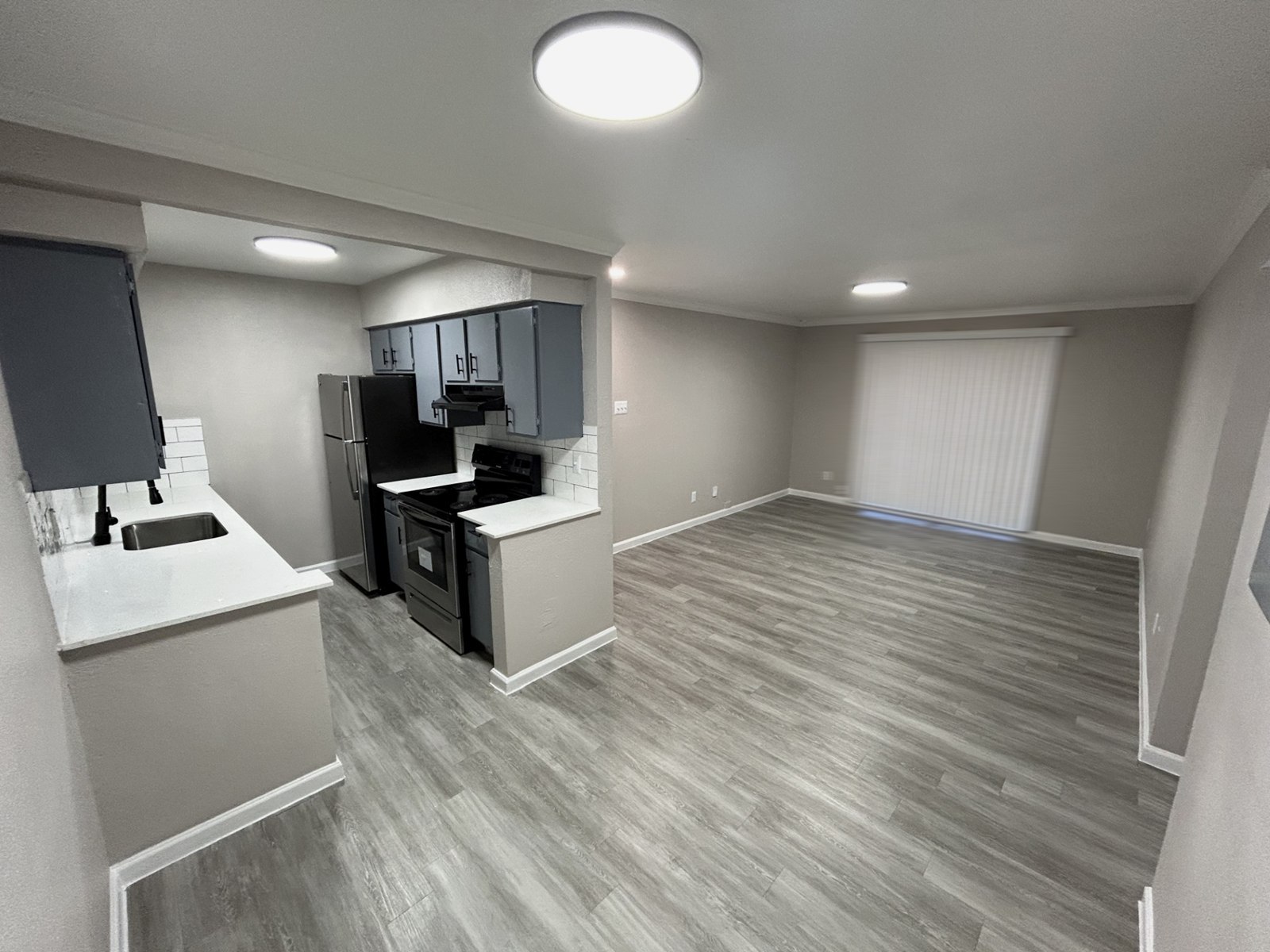 Premium open kitchen layout flowing into the living room, with plank flooring